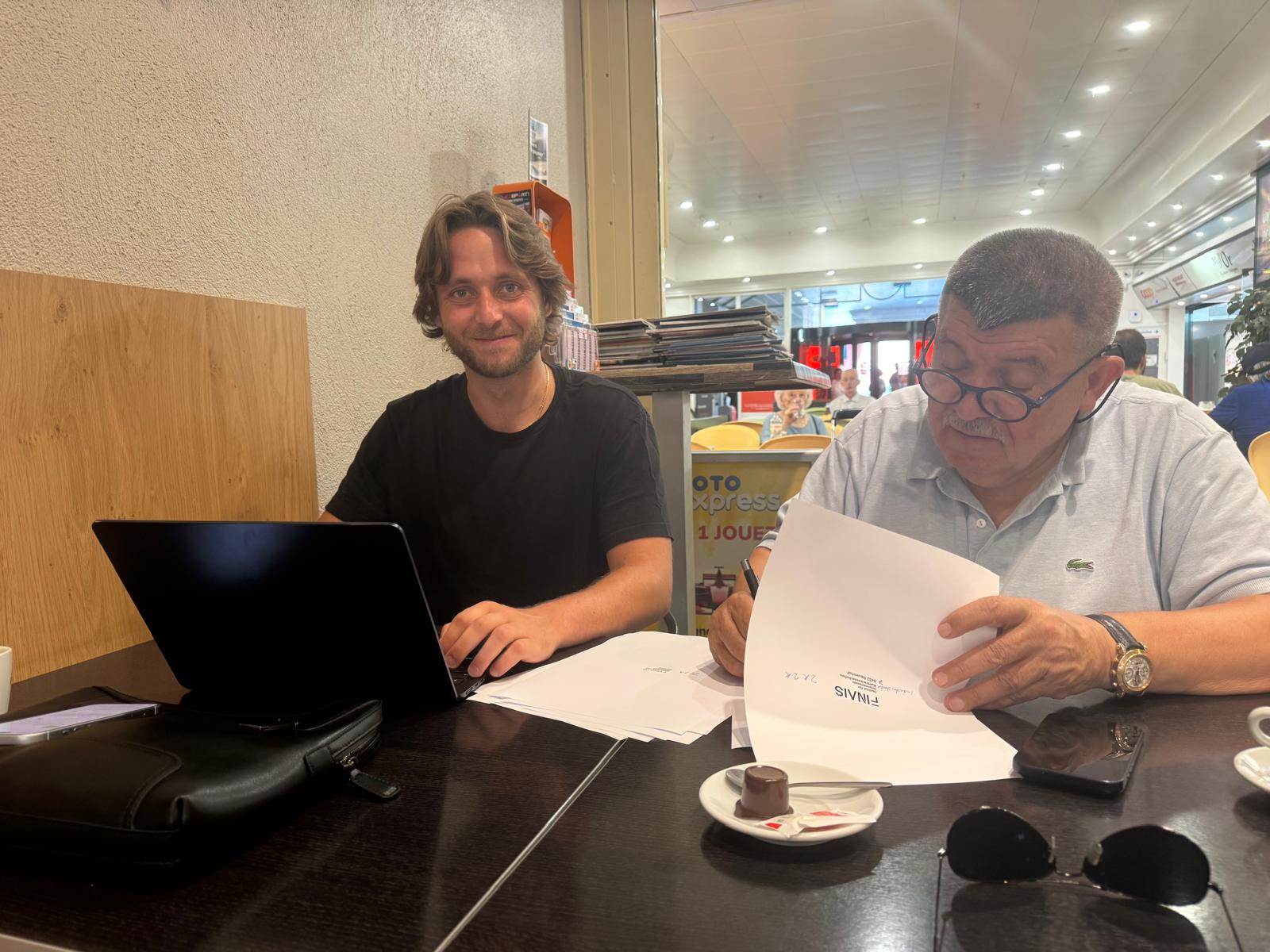 Andranik Ghazarian reviewing documents with (Working session: Paperwork, over coffee)