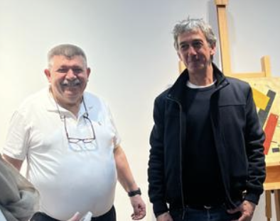 Andranik Ghazarian with, beside a work on the easel (Studio: Standing with the picture)