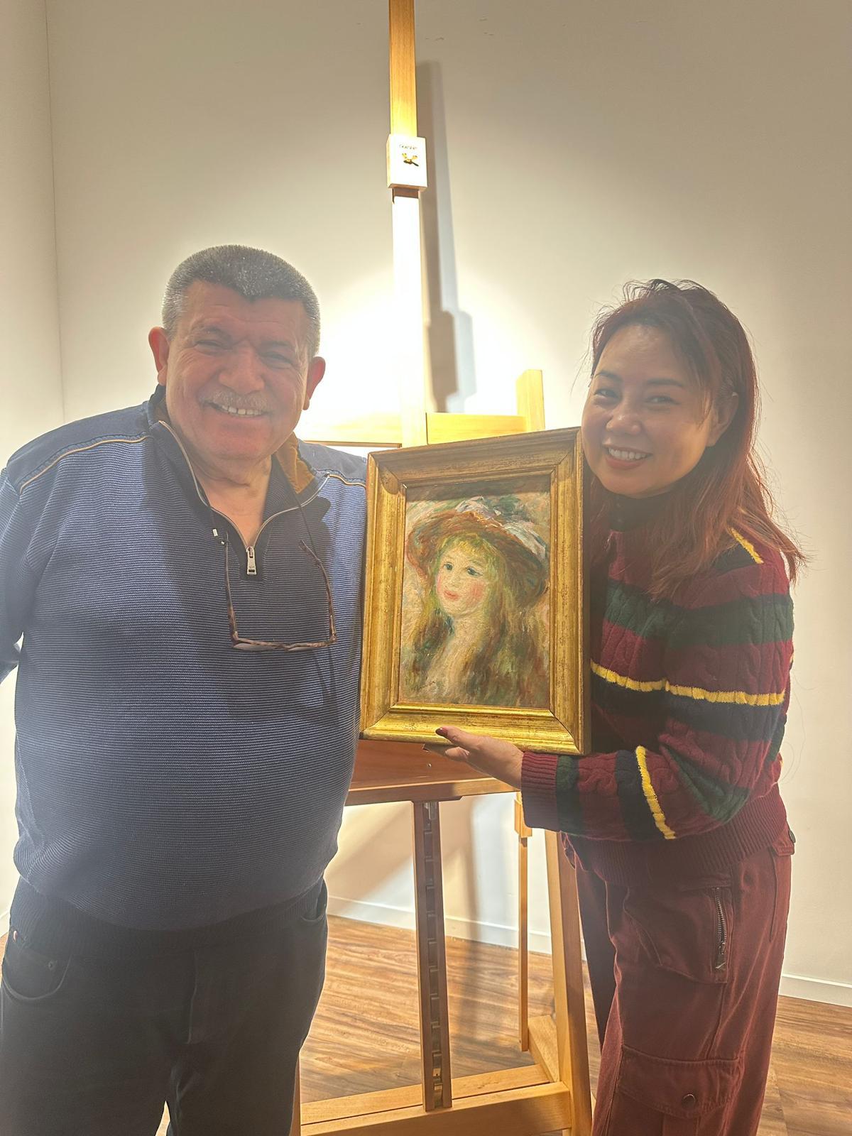 Andranik Ghazarian — Andranik Ghazarian presenting a framed work from the FINAIS Collection during a curatorial visit.