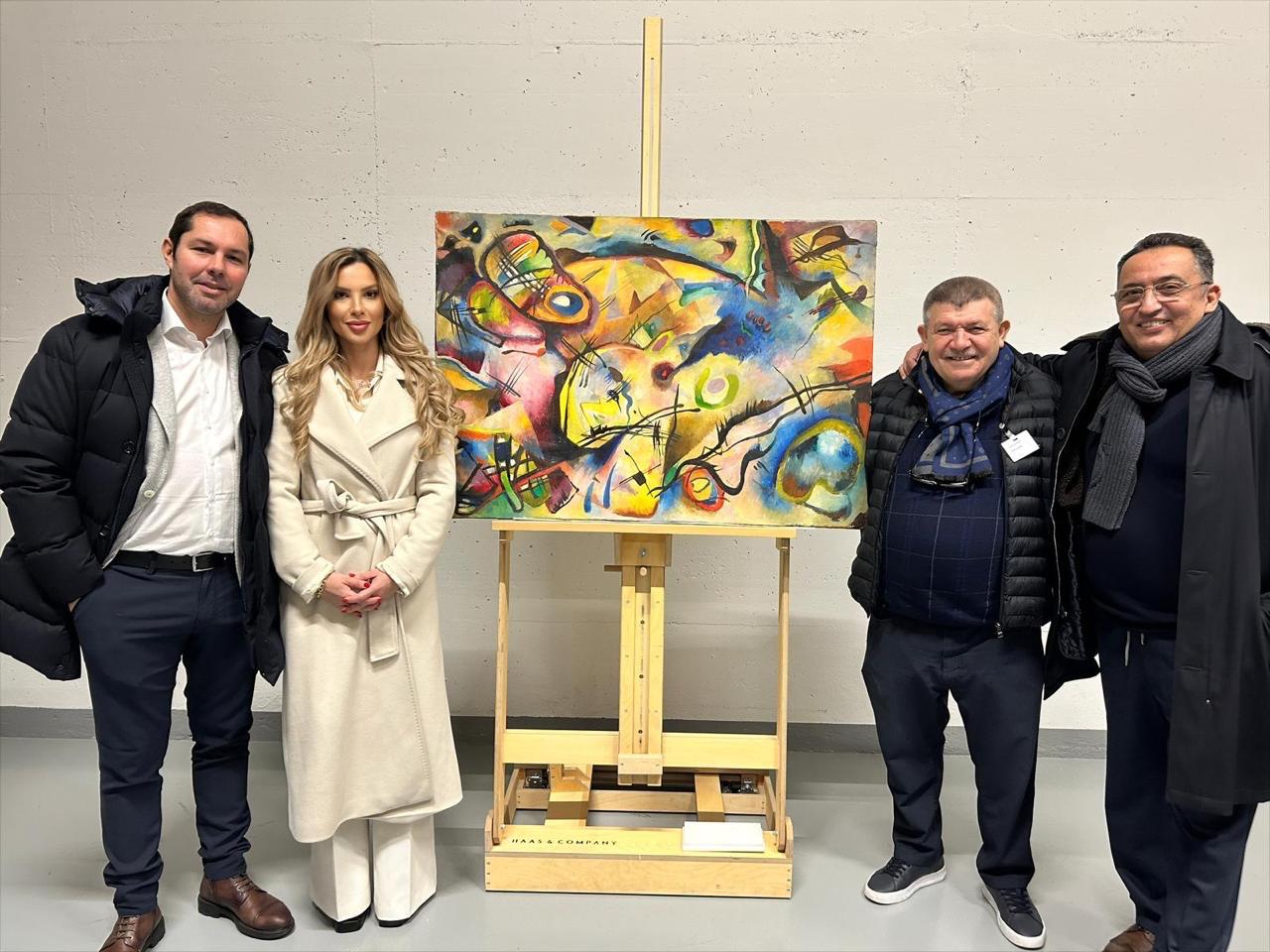 Andranik Ghazarian — Andranik Ghazarian with guests beside a modern abstract painting placed on the easel.